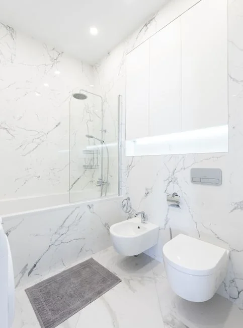 Anonymous person in yellow rubber gloves using simple sponge for cleaning mirror in bathroom
